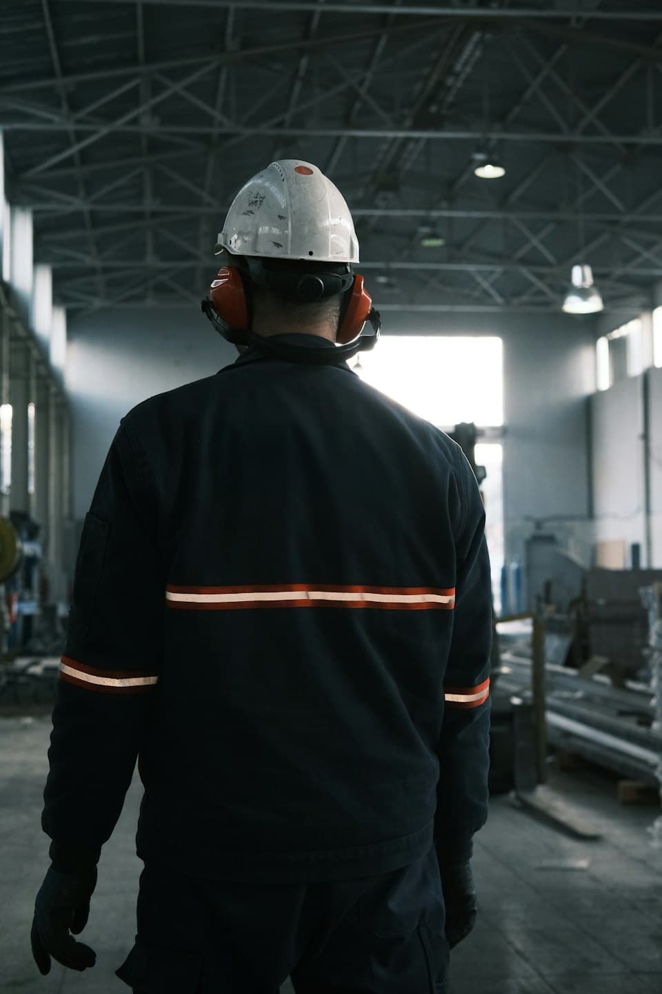 Arbetare i hjälm inspekterar ett stort industriellt lager.