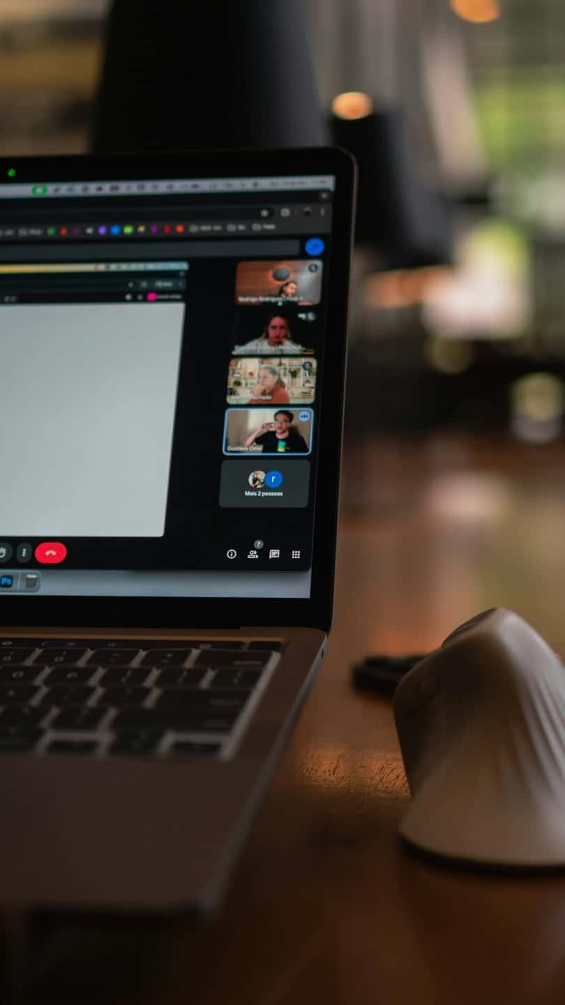 Dator som visar videokonferens på ett träskrivbord.